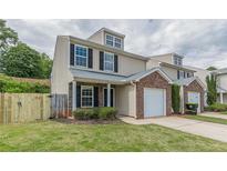 Charming townhome with brick accents, an attached garage, and a well-maintained lawn at 150 Alton Cir, Villa Rica, GA 30180