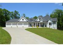 Charming home featuring a three-car garage, manicured lawn, and long driveway at 8 Ripplewood Trl, Euharlee, GA 30145