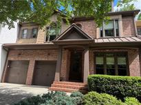 Charming brick home with a two-car garage, complemented by mature landscaping and a welcoming entrance at 2664 Long Pointe, Johns Creek, GA 30076