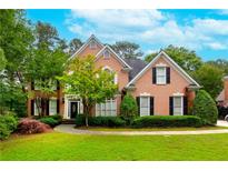Charming two-story brick home with manicured lawn and mature landscaping at 1000 Admiral Xing, Alpharetta, GA 30005