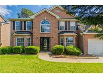 Traditional two-story brick home featuring a manicured lawn and a classic front door design at 1013 Odelle Cir, Mcdonough, GA 30253
