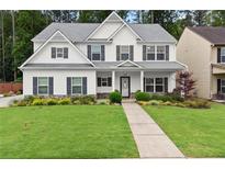 Charming two-story home boasts a well-manicured lawn, welcoming front porch, and classic design details at 336 Parc Xing, Acworth, GA 30102