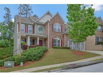 Charming two-story home with brick facade, red shutters, landscaped front yard, and a two-car garage at 760 King Sword Ct, Mableton, GA 30126