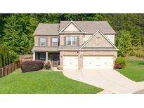Beautiful two-story brick home with a well-manicured lawn and attached two-car garage at 149 Manor Ln, Woodstock, GA 30188