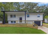 Charming exterior elevation view of a home with modern design elements and a well-maintained lawn at 2184 Cherokee Valley Cir, Lithonia, GA 30058