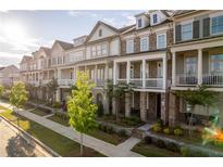 Charming townhomes featuring brick exteriors, covered porches, manicured lawns, and a welcoming neighborhood setting at 963 South On Main Dr, Woodstock, GA 30188