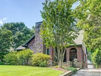 Charming brick home with stone chimney, lush landscaping, and covered arched entryway offering curb appeal at 1356 Emory Ne Rd, Atlanta, GA 30306