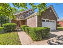 Charming brick and stone home with manicured bushes and a well-maintained lawn at 484 Cathedral Dr, Mcdonough, GA 30253
