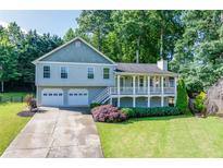 Charming two-story home featuring a covered front porch and a two-car garage at 850 Old Spring Way, Sugar Hill, GA 30518