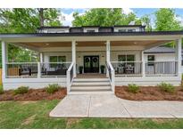 Charming white brick home with a covered porch, black accents, and well-manicured lawn at 550 Stewart Nw Ave, Marietta, GA 30064