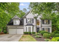 Charming two-story home with a well-manicured lawn, two-car garage and inviting front entrance framed by lush greenery at 3953 Lorien Nw Way, Kennesaw, GA 30152
