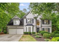 Charming two-story home featuring a two-car garage, landscaped yard, and a classic design with black shutters and gray siding at 3953 Lorien Nw Way, Kennesaw, GA 30152