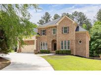 Beautiful brick home featuring manicured landscaping, a three-car garage, and a welcoming front entrance at 3512 Centerville Rosebud Rd, Snellville, GA 30039