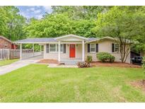 Charming ranch home with a well-manicured lawn, bright red door, and covered parking at 733 San Fernando Se Dr, Smyrna, GA 30080