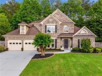 Two-story brick home with a three-car garage and manicured lawn at 3707 Lance Bluff Ln, Duluth, GA 30097