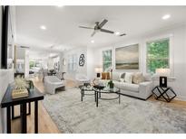 Bright, open-concept living room with modern furnishings and hardwood floors, seamlessly connecting to the kitchen and dining area at 770 Ormewood Se Ave, Atlanta, GA 30312