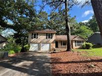 Charming split-level home features a two-car garage and a welcoming front porch at 1090 Forest Path, Stone Mountain, GA 30088