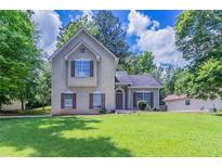 Charming two-story home with neutral siding, dark shutters, and a well-manicured lawn on a sunny day at 12241 Cypress Way, Fayetteville, GA 30215