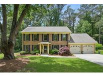 Charming brick two-story home featuring a three-car garage and a well-manicured front lawn at 878 Park Creek Sw Ct, Marietta, GA 30064