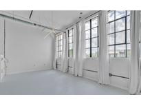 Bright, airy living room with large windows, white walls, and modern lighting for a serene, loft-like atmosphere at 881 Memorial Se Dr # 307, Atlanta, GA 30316