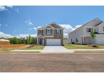 Inviting two-story home featuring brick accents, a two-car garage, and professionally landscaped front yard at 17 Camellia Dr, Fairburn, GA 30213