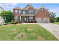 Charming two-story brick home with a well-manicured lawn and a two-car garage at 4060 Brumby Ln, Cumming, GA 30041