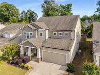 Charming two-story home features a neutral color scheme, well-manicured landscaping, and an attached two-car garage at 122 Grove View Rd, Woodstock, GA 30189