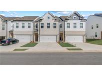 Charming townhomes with brick and white siding and individual one car garages at 903 Eagle Ave, Riverdale, GA 30296