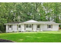 Charming white-brick single-story home with a well-manicured lawn, fresh landscaping and mature trees at 2110 Argyle Se Dr, Smyrna, GA 30080