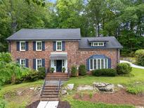 Charming two-story brick home featuring a well-manicured lawn and a serene water feature at 2719 Cravey Ne Dr, Atlanta, GA 30345