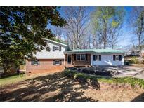 Charming two-story home with brick accents and a green metal roof, set on a landscaped lot at 6225 Pebble Dr, Douglasville, GA 30135