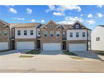 New townhomes feature brick and siding exteriors, attached garages, and landscaping at 907 Eagle Ave, Riverdale, GA 30296