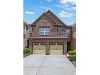 Charming two-story brick townhome with a two-car garage and well-maintained landscaping at 1929 Brightleaf Way, Marietta, GA 30060