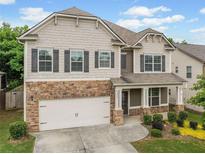 Charming two-story home featuring stone accents, a two-car garage, and a welcoming front porch at 3805 Alden Pl, Cumming, GA 30028