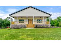 Charming home featuring a lovely covered porch with wooden accents and a brick foundation at 6054 Heritage Se Way, Mableton, GA 30126