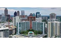Stunning aerial view of luxury high-rise condominiums and the city skyline with rooftop pool and lush landscaping at 950 W Peachtree Nw St # 1613, Atlanta, GA 30309