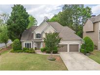 Charming two-story home featuring a well-manicured lawn, two-car garage, and inviting curb appeal in a lush, green neighborhood at 1199 Kenway Se Cir, Smyrna, GA 30082