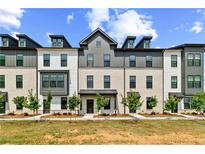 Modern townhome exterior with brick and siding, featuring dormer windows and manicured landscaping at 525 Rubato Knl, Mcdonough, GA 30253