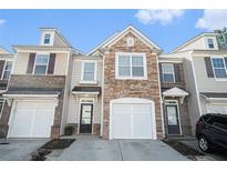Charming townhome featuring a stone facade, attached garage, and inviting entryway at 1954 Durwood Ln, Duluth, GA 30096