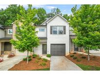 Charming townhome with a painted brick facade, well-manicured landscaping, and a one-car garage at 3181 Meadowstone Sw Ln, Atlanta, GA 30331