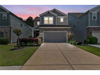 Charming two-story home with a gray garage door, stone accents, and a well-manicured lawn at 3255 Morgan Rd, Buford, GA 30519