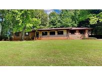 Charming single-story brick home with a lush green lawn and mature trees at 3284 Salem Se Ln, Conyers, GA 30013