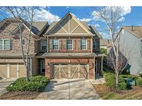 Inviting two-story brick townhome with a two-car garage and a well-manicured lawn at 5711 Keys Way, Lithonia, GA 30058