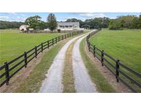 Picturesque home featuring a long driveway, fenced pasture, and an inviting country setting at 654 Euharlee Five Forks Rd, Kingston, GA 30145