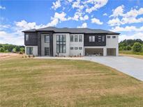 New construction two-story home featuring mixed brick design, black trim, and attached three-car garage at 2021 Jones Phillips Rd, Dacula, GA 30019