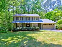 Charming two-story home with a well-manicured lawn, mature trees, and attached two car garage at 351 Ridgewater Dr, Marietta, GA 30068