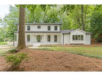 Beautiful two-story home with a white brick exterior, black trim, and a welcoming front porch at 418 Mockingbird, Smyrna, GA 30082