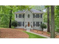 Charming gray two-story home featuring black shutters, a landscaped yard, and mature trees at 3267 Standing Peachtree Nw Trl, Kennesaw, GA 30152