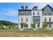 Modern townhome with a manicured lawn, complemented by young trees and a welcoming front entrance at 533 Rubato Knl, Mcdonough, GA 30253