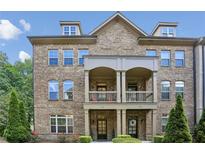Charming brick townhome with a covered front porch and well-maintained landscaping at 600 Luckett Ct, Smyrna, GA 30080
